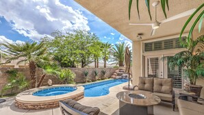 A backyard with a swimming pool, outdoor seating, and potted plants. - Tranquil Henderson Retreat with Pool & Spa! (Henderson)