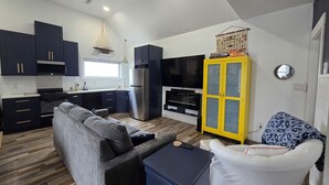 A compact living space with a kitchenette, sofa, TV, and a yellow cabinet. - Edgewater Pirates Den. Water Front 2nd story apt.  1 bedroom, bath & kitchen.
 (Hertford)