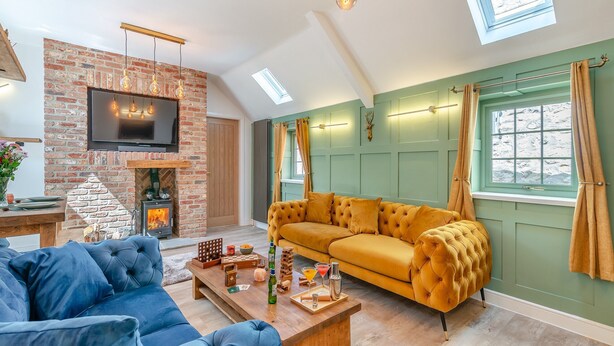 Ein Wohnzimmer mit Kamin aus Ziegelsteinen, einer Couch, einem Couchtisch und einem Fernseher.