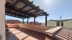 Un espacio al aire libre cubierto con piso de ladrillo, un banco y vistas de edificios al fondo.