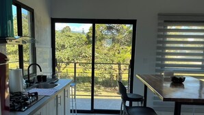 A modern kitchen with a view of a balcony and garden.