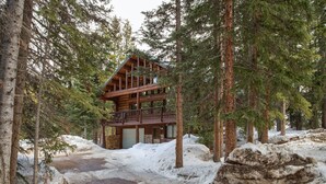A log cabin with a balcony, surrounded by snow and trees. - Great Condo close to the mountain (Breckenridge)