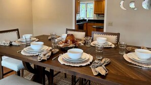 Comedor con mesa de madera dispuesta para seis personas, rodeada de sillas.