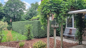 A well-maintained garden with a hedge, wooden pergola, and seating area. - Nice home in Kilder with kitchen (Kilder)