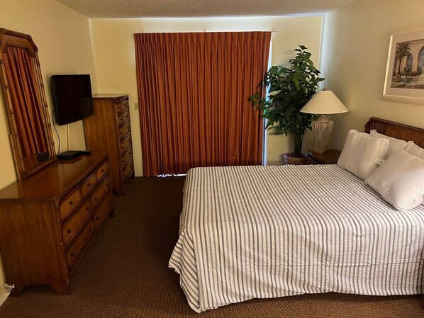 A hotel room with a bed, a television, a dresser, a lamp, and a potted plant. - TimeOut 2! Spacious 2 bed/2bath condo, Sleeps 6, Pool! (Mulberry)