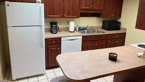 A compact kitchen with wooden cabinets, a refrigerator, a coffee maker, a microwave, and a sink. - TimeOut 2!  Spacious 2 bed/2bath condo, Sleeps 6, Pool! (Mulberry)