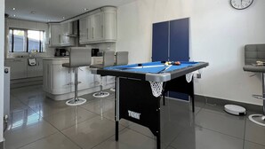 A modern kitchen with white cabinets, a built-in oven, and a dining area with a pool table. - The Grey Mansion near Manchester City Stadium, Co-Ops LIVE, Piccadilly... (Manchester)