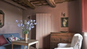 Une pièce chaleureuse avec une table en bois, un canapé bleu, une chaise blanche et un meuble en bois.