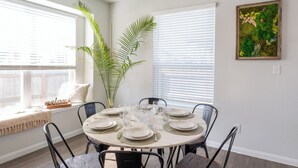 A dining area with a round table set for four, surrounded by black chairs. - 🏈 GAME DAY WATCH PARTY!  (Bryan)