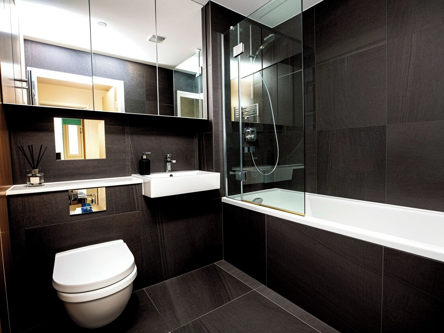 Une salle de bain moderne équipée de toilettes, d’un lavabo et d’une douche.