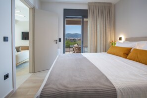 A hotel room with a bed, a view of the outdoors, a balcony, and a television on the wall.