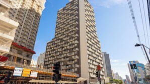 A high-rise building with multiple balconies and a clear blue sky. - NOV - NEXT ONE Vila Nova Conceição (São Paulo)