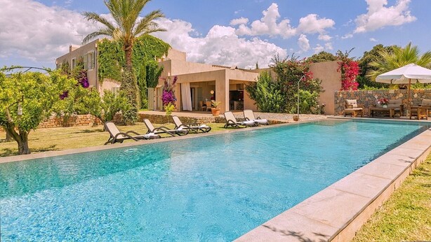 A swimming pool with lounge chairs, a building with a patio, and surrounding greenery. - Country House 'Son Puca 1' with Private Pool, Wi-Fi and Air Conditioning (Illes Balears)