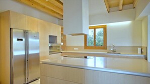 A modern kitchen with built-in appliances, a large island, and a window with a view. - Country House 'Son Puca 1' with Private Pool, Wi-Fi and Air Conditioning (Illes Balears)
