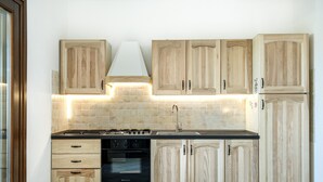 A kitchen with wooden cabinets, a stove, and a tiled backsplash.