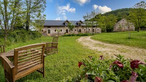 A rustic building with a gravel path leading to a wooden bench.