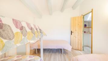 Una camera da letto con una cuccetta, un letto singolo, un'armadietto in legno e una parete con opere d'arte astratte.