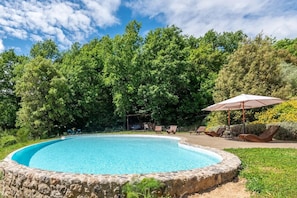 A swimming pool surrounded by lush greenery, with a covered seating area and a small pavilion. - Farmhouse 'Casa Luna' with Shared Infinity Saltwater Pool, Private Terrace and Wi-Fi (Chiusdino)