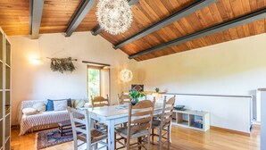 A dining area with a wooden table and chairs, a hanging light fixture, and a view of the outdoors. - Farmhouse 'Casa Stella' with Infinity salt water pool shared, Private Terrace and Wi-Fi (Chiusdino)