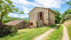 A stone building with a wooden door, a small porch, and a dirt path leading to it. - Farmhouse 'Casa Stella' with Infinity salt water pool shared, Private Terrace and Wi-Fi (Chiusdino)