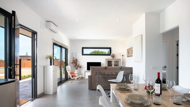 A modern kitchen with a dining area, a sofa, and a TV. - Holiday Home 'Casa Valle' with Private Pool, Wi-Fi and Air Conditioning (Conil de la Frontera)