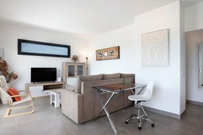 Una sala de estar moderna con un sofá, televisor y obras de arte en la pared.