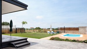 A backyard with a swimming pool, a covered patio, and a lawn. - Holiday Home 'Casa Valle' with Private Pool, Wi-Fi and Air Conditioning (Conil de la Frontera)