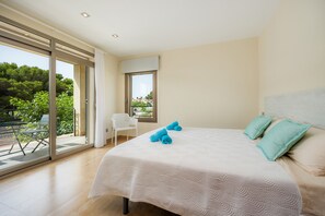 A bedroom with a large bed, a chair, a window, and a balcony. - Holiday Home 'Casa Juan' with Sea View, Wi-Fi and Air Conditioning (Can Picafort)