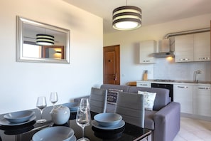 Una cocina moderna con comedor, espejo y sofá con cojines.