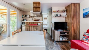 A compact living space with a kitchen, dining area, and a red sofa.