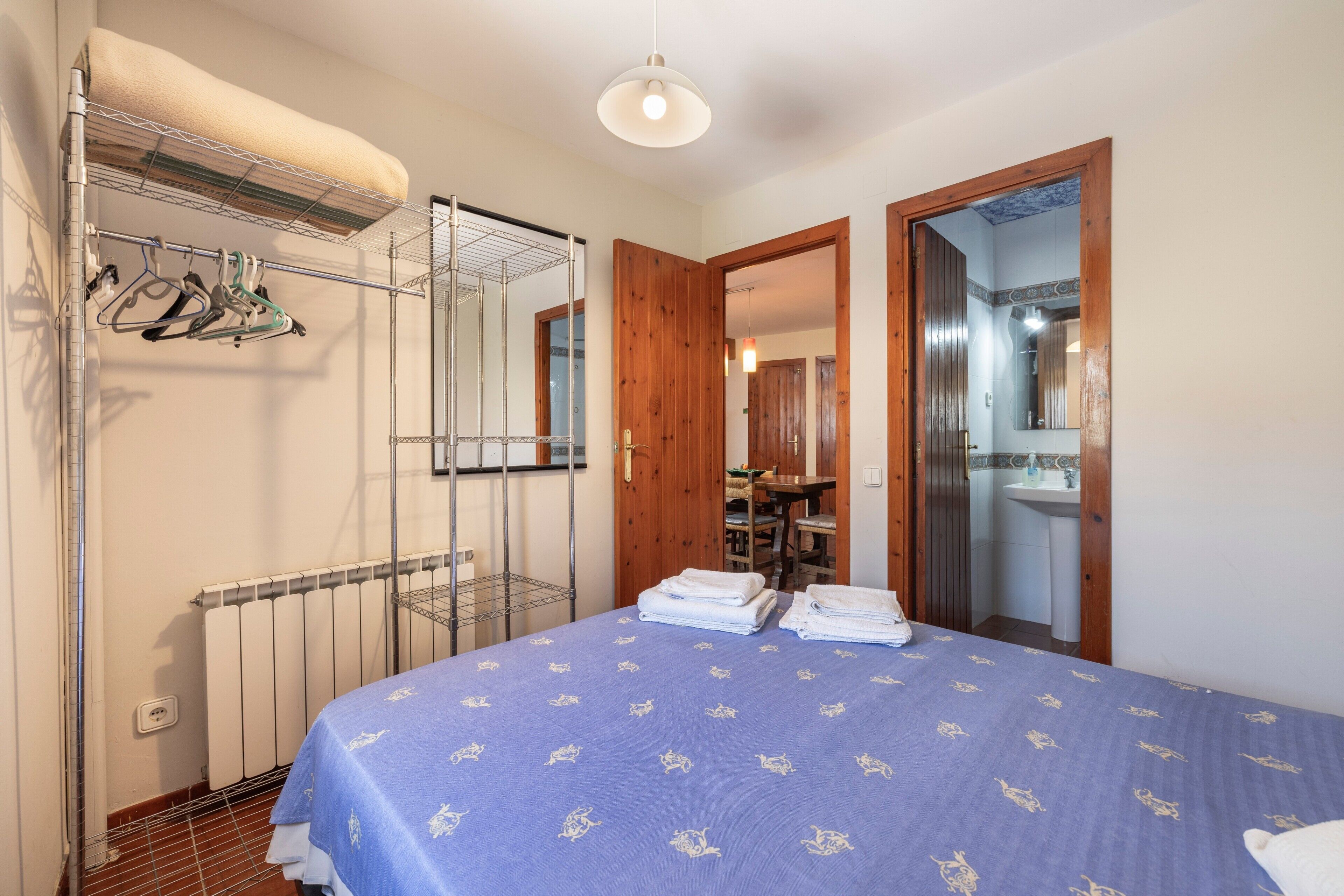 Ein Schlafzimmer mit einem Bett, einem Heizkörper, einem Kleiderschrank und einem Spiegel.