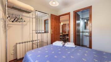 Ein Schlafzimmer mit einem Bett, einem Heizkörper, einem Kleiderschrank und einem Spiegel.