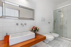 A modern bathroom with a large mirror, a bathtub, a toilet, and a glass-enclosed shower. - Holiday Home 'Romantic Apartment Metro Flaminio' with Wi-Fi and Air Conditioning (Roma)