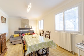 Ein Essbereich mit Tisch, Stühlen, einer Couch und einer Heizung.