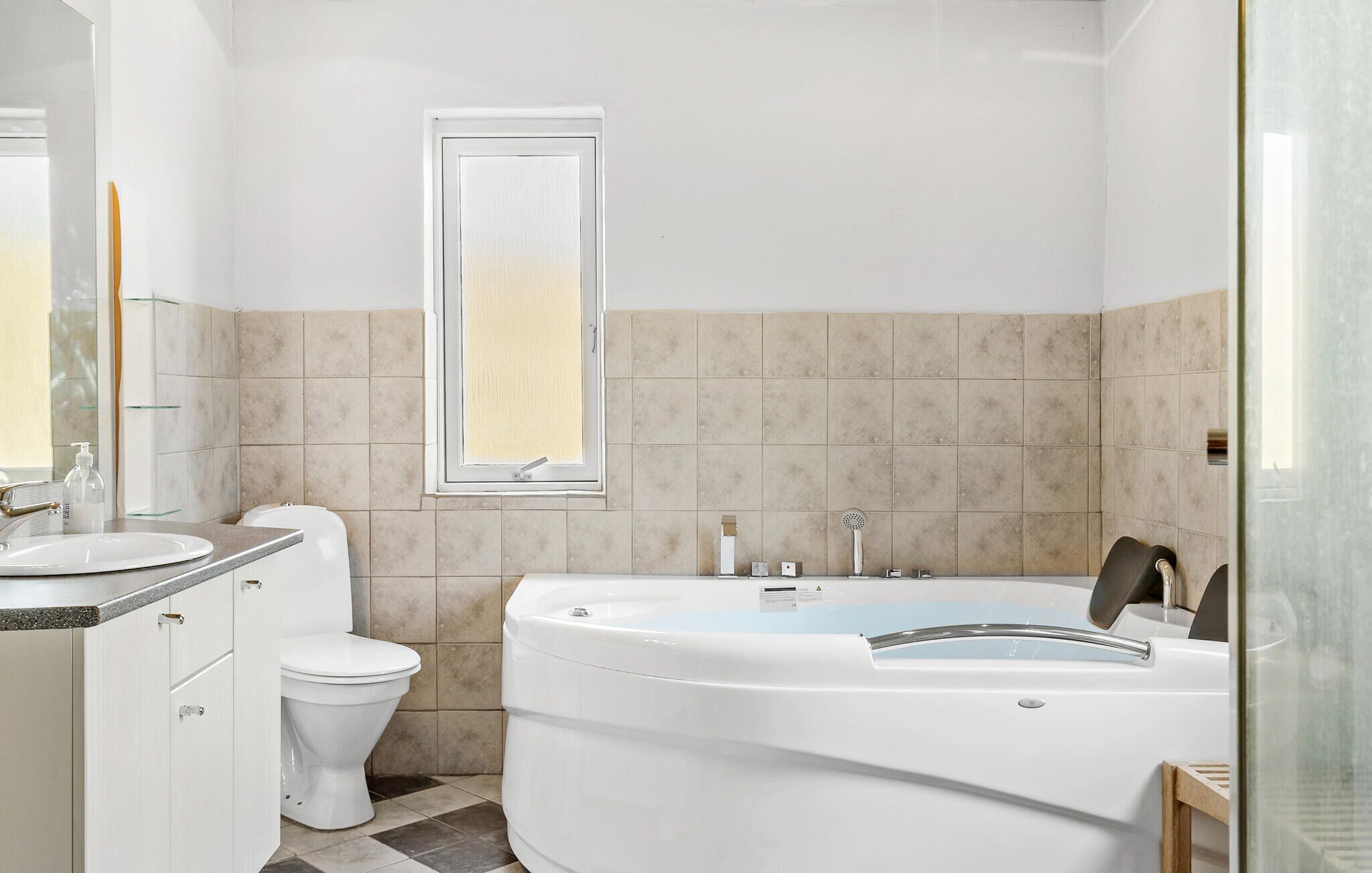 A modern bathroom with a toilet, sink, and bathtub.