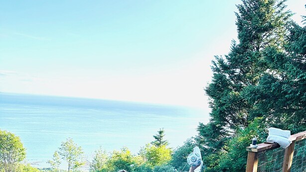 Ett bubbelbad på ett trädäck med utsikt över havet.