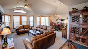 A spacious living room with leather sofas, a coffee table, and a wooden cabinet. - Pet Friendly, fenced in Yard and Huge Pool! Sound Views, 2 min walk to Ocean (Waves)