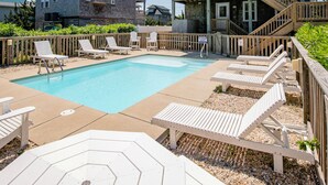 A swimming pool with lounge chairs and a wooden deck. - Pet Friendly, fenced in Yard and Huge Pool! Sound Views, 2 min walk to Ocean (Waves)