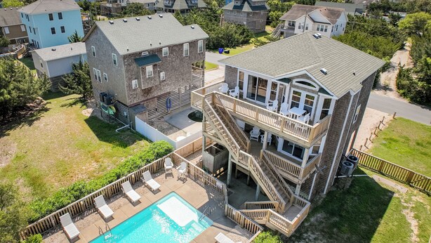 A multi-story building with a pool, outdoor seating, and a view of the surrounding neighborhood. - Pet Friendly, fenced in Yard and Huge Pool! Sound Views, 2 min walk to Ocean (Waves)