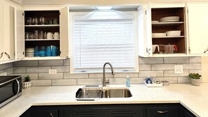 A kitchen with a built-in microwave, a sink with a dish rack, and cabinets with dishes and glassware. - 3B Spacious Home+ Free Parking near Chicago O'Hare (Franklin Park)