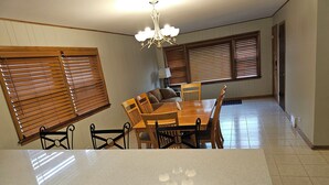 A kitchen with a dining table, chairs, wooden blinds, a chandelier, and a tiled floor. - 3B Spacious Home+ Free Parking near Chicago O'Hare (Franklin Park)