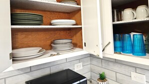 A kitchen with white cabinets, a black microwave, and a small potted plant. - 3B Spacious Home+ Free Parking near Chicago O'Hare (Franklin Park)