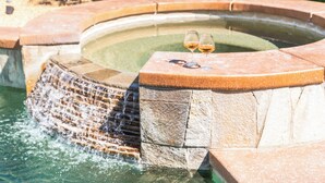 A stone hot tub with two glasses of wine on the edge. - Desert Oasis w/Pool, Spa & more! (Coachella)