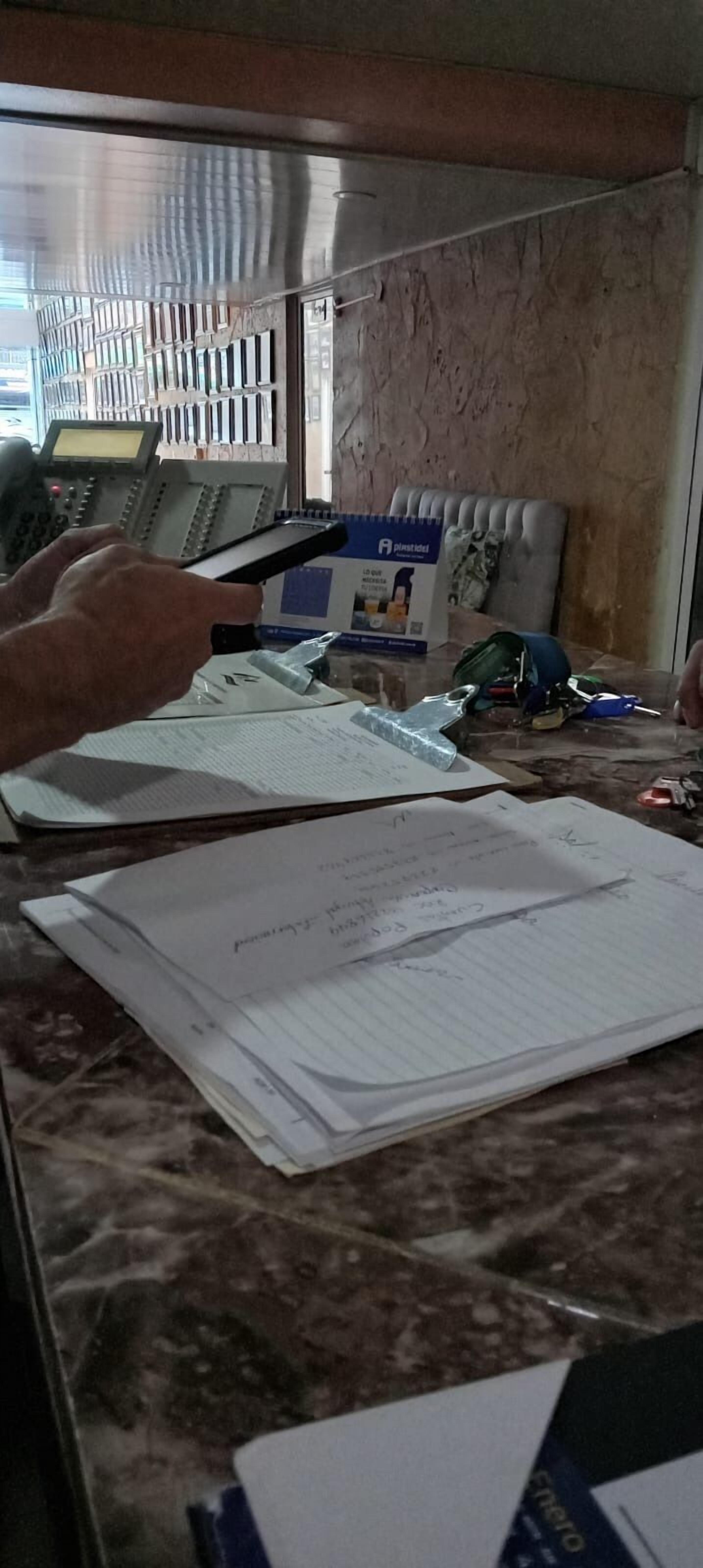 Una reception con telefono, documenti e una insegna blu.