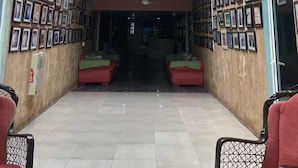 Un hall d’entrée spacieux avec un plafond haut, une verrière et un lustre.