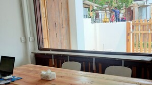 Une table en bois, des chaises, un ordinateur portable et des mouchoirs.