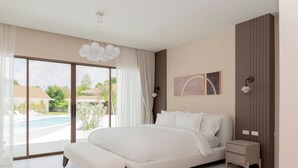 Quarto moderno com uma cama grande, mesa de cabeceira, vista para uma piscina e luminária no teto.