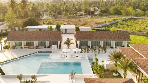 Um resort com piscina, espreguiçadeiras e vista para a paisagem ao redor.