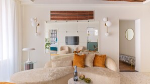 A modern living room with a sectional sofa, a glass coffee table, and a large mirror. - Charming Canal View Apartment in Idyllic Location (Venecia)
