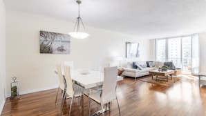 A modern living room with a dining area, white furniture, and large windows. - Awesome Miami Sunny Isles Ocean Reserve Condo (Sunny Isles Beach)